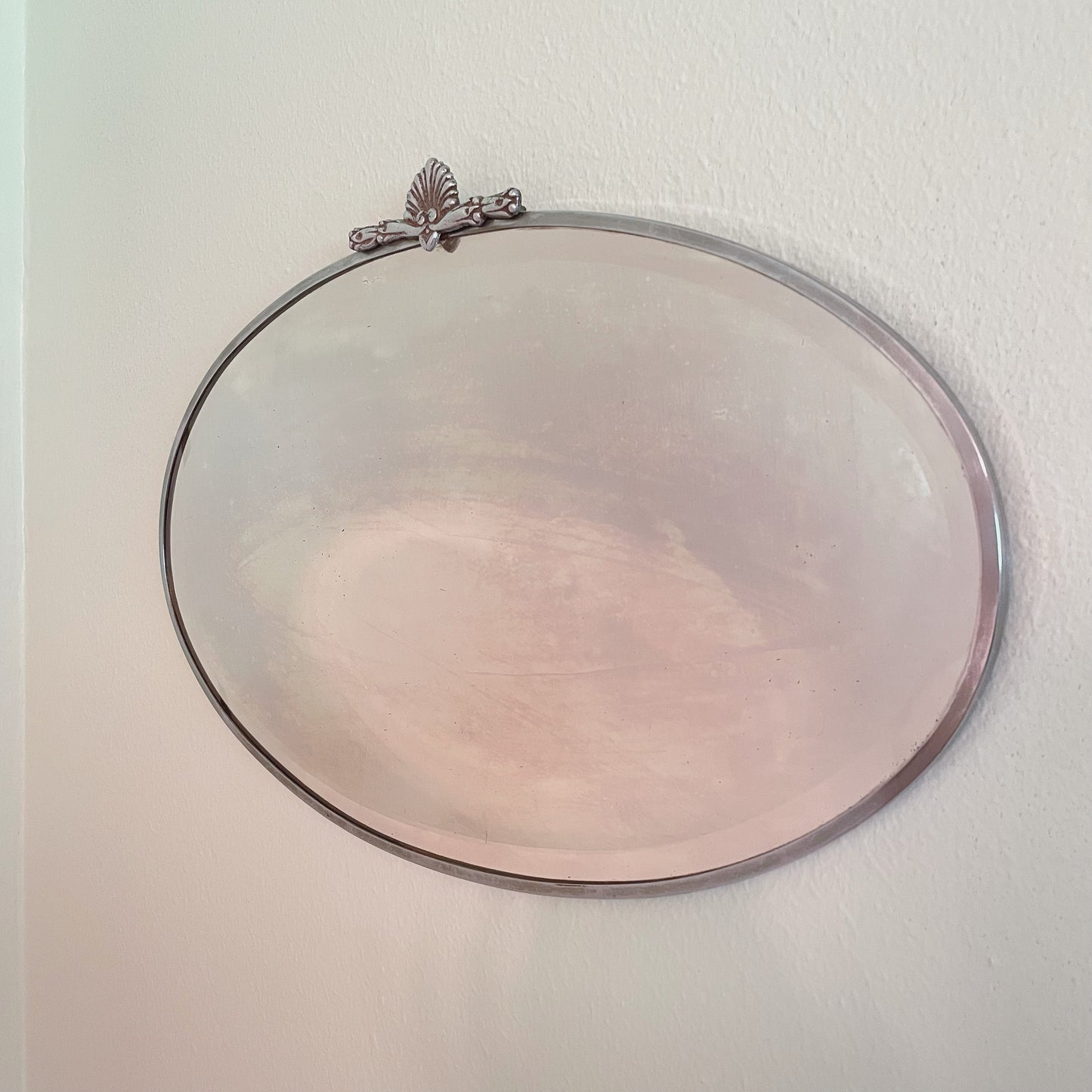 Art Deco beveled mirror with metal frame and decorative topper