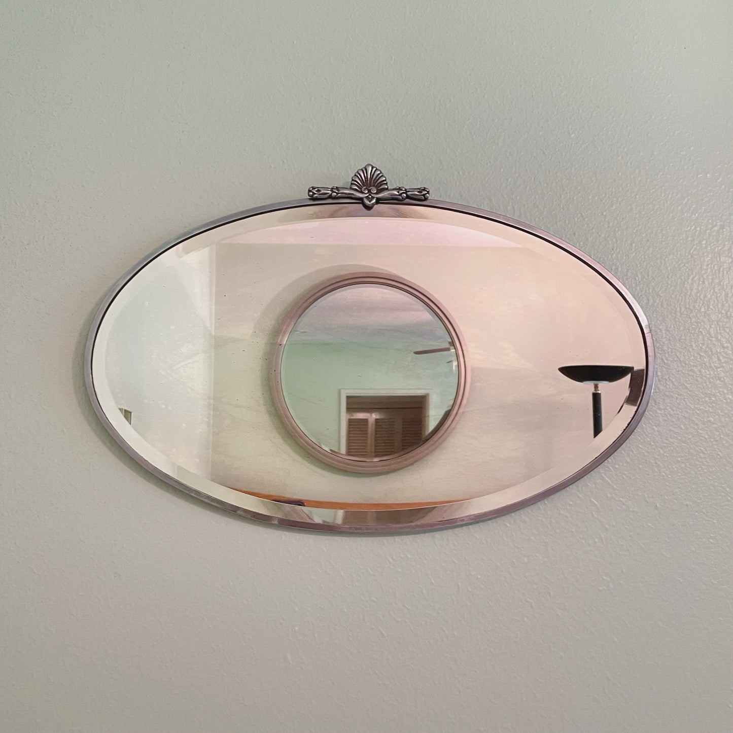 Art Deco beveled mirror with metal frame and decorative topper