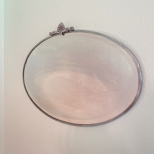 Art Deco beveled mirror with metal frame and decorative topper