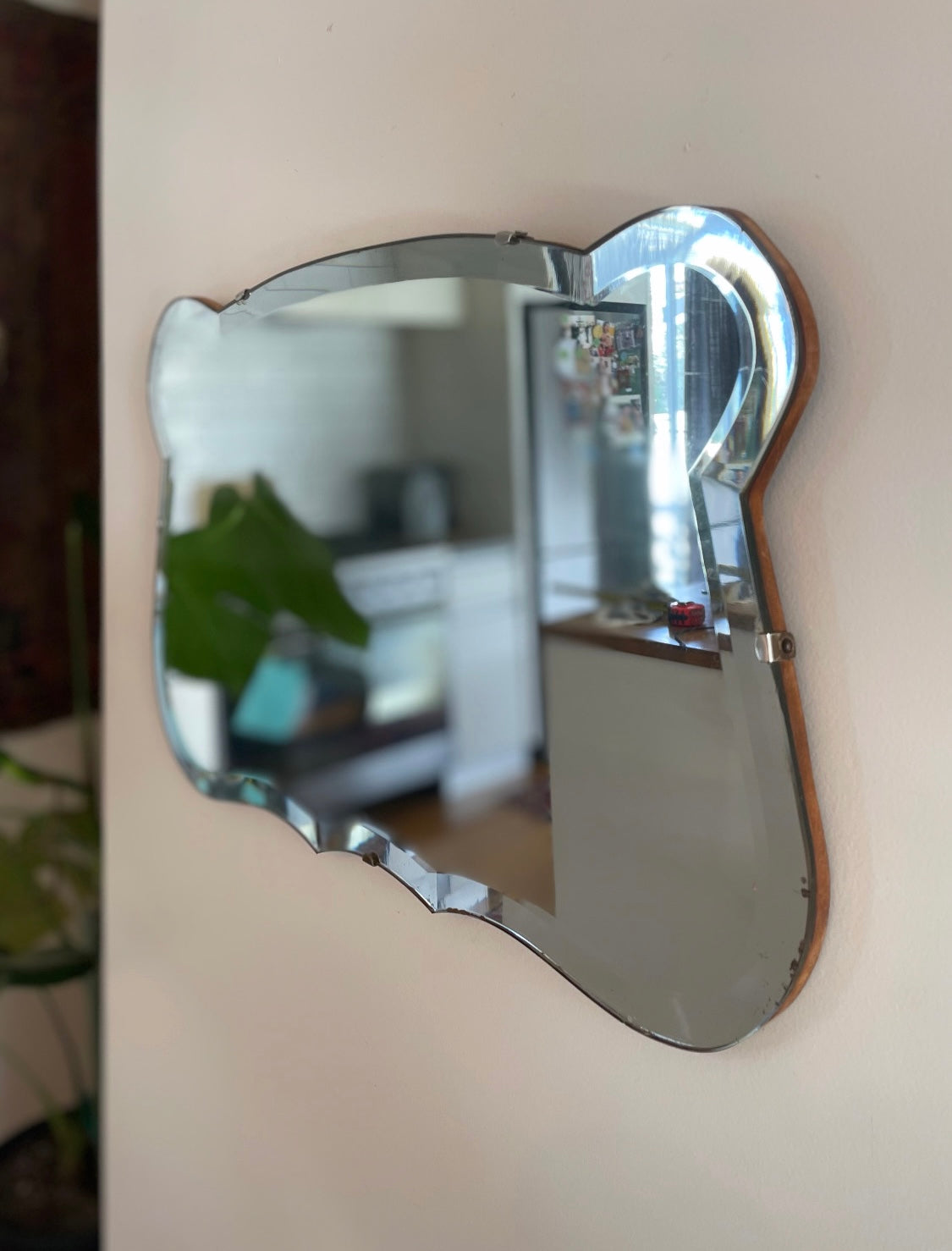 Antique 1930s Art Deco mirror with curving shape and thick beveled edges