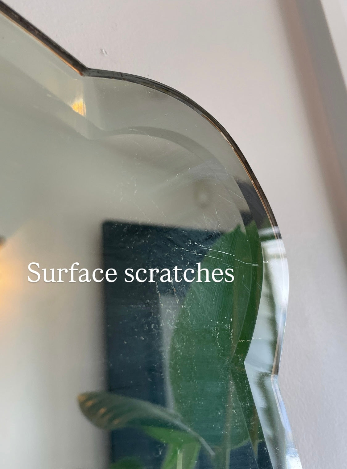Antique 1930s Art Deco mirror with curving shape and thick beveled edges