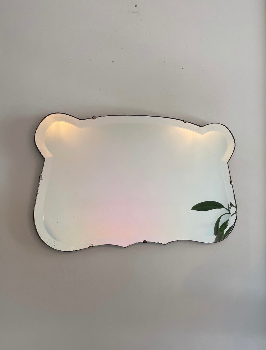 Antique 1930s Art Deco mirror with curving shape and thick beveled edges