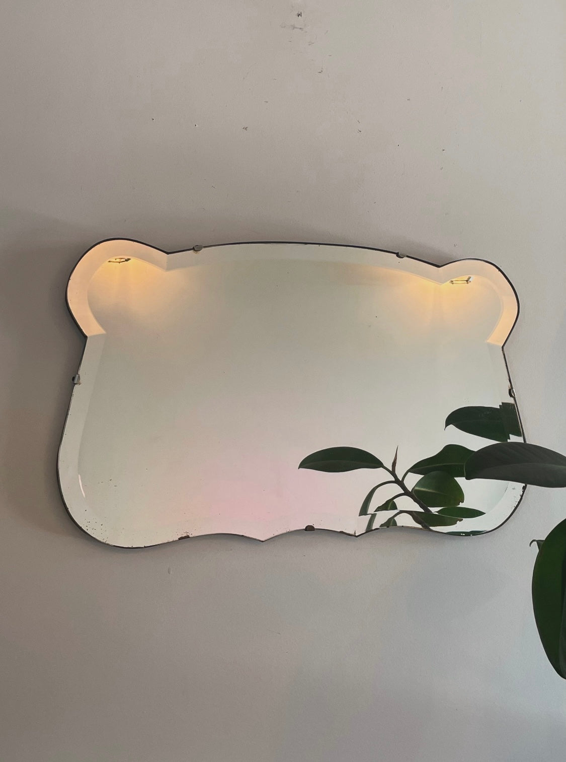 Antique 1930s Art Deco mirror with curving shape and thick beveled edges