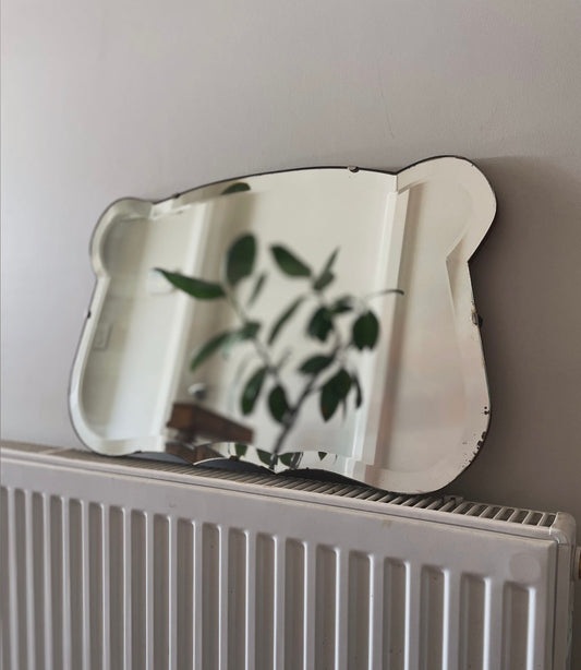Antique 1930s Art Deco mirror with curving shape and thick beveled edges