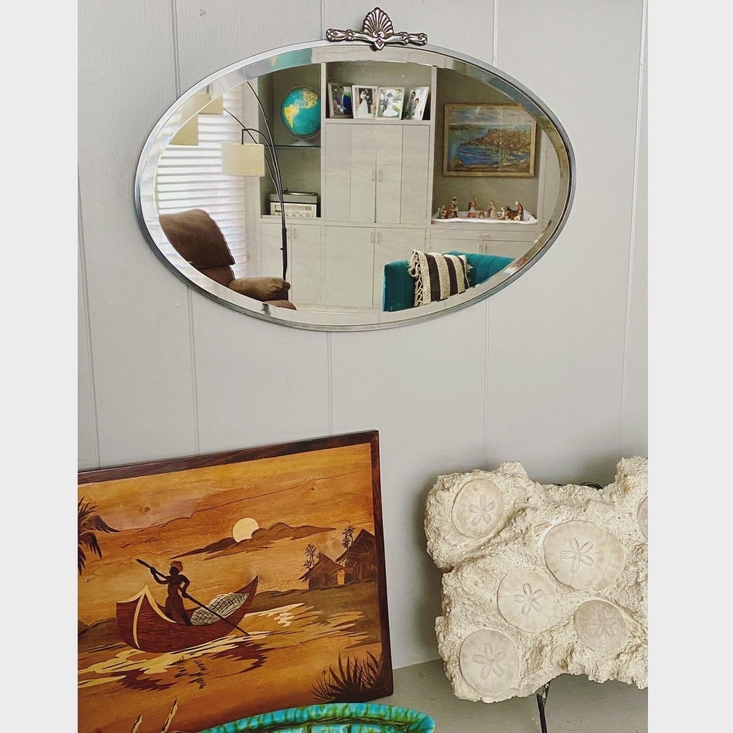 Art Deco beveled mirror with metal frame and decorative topper