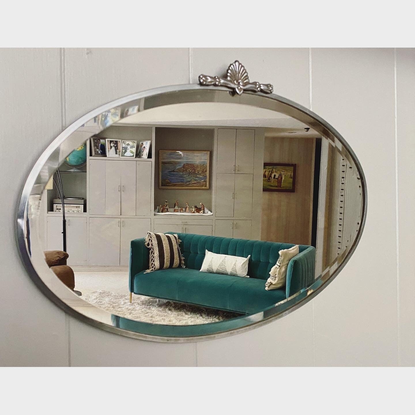 Art Deco beveled mirror with metal frame and decorative topper