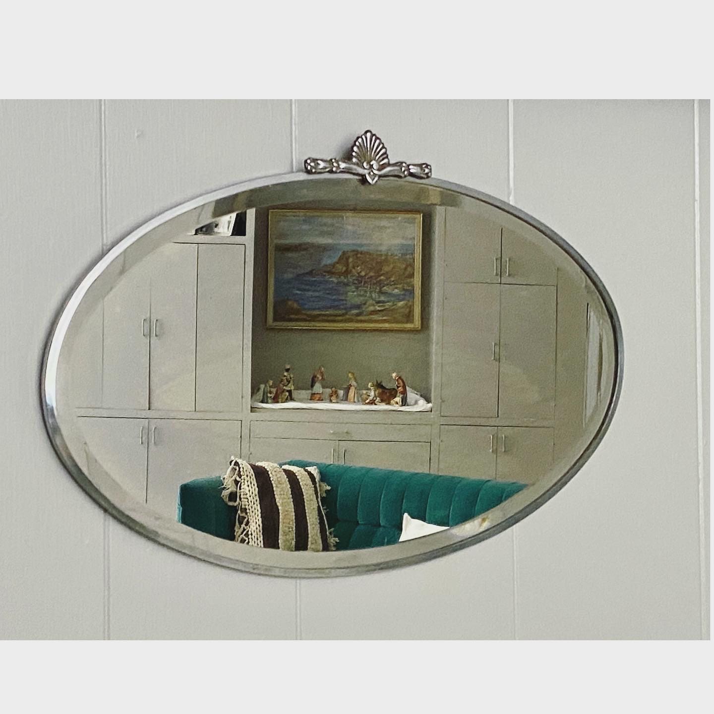 Art Deco beveled mirror with metal frame and decorative topper