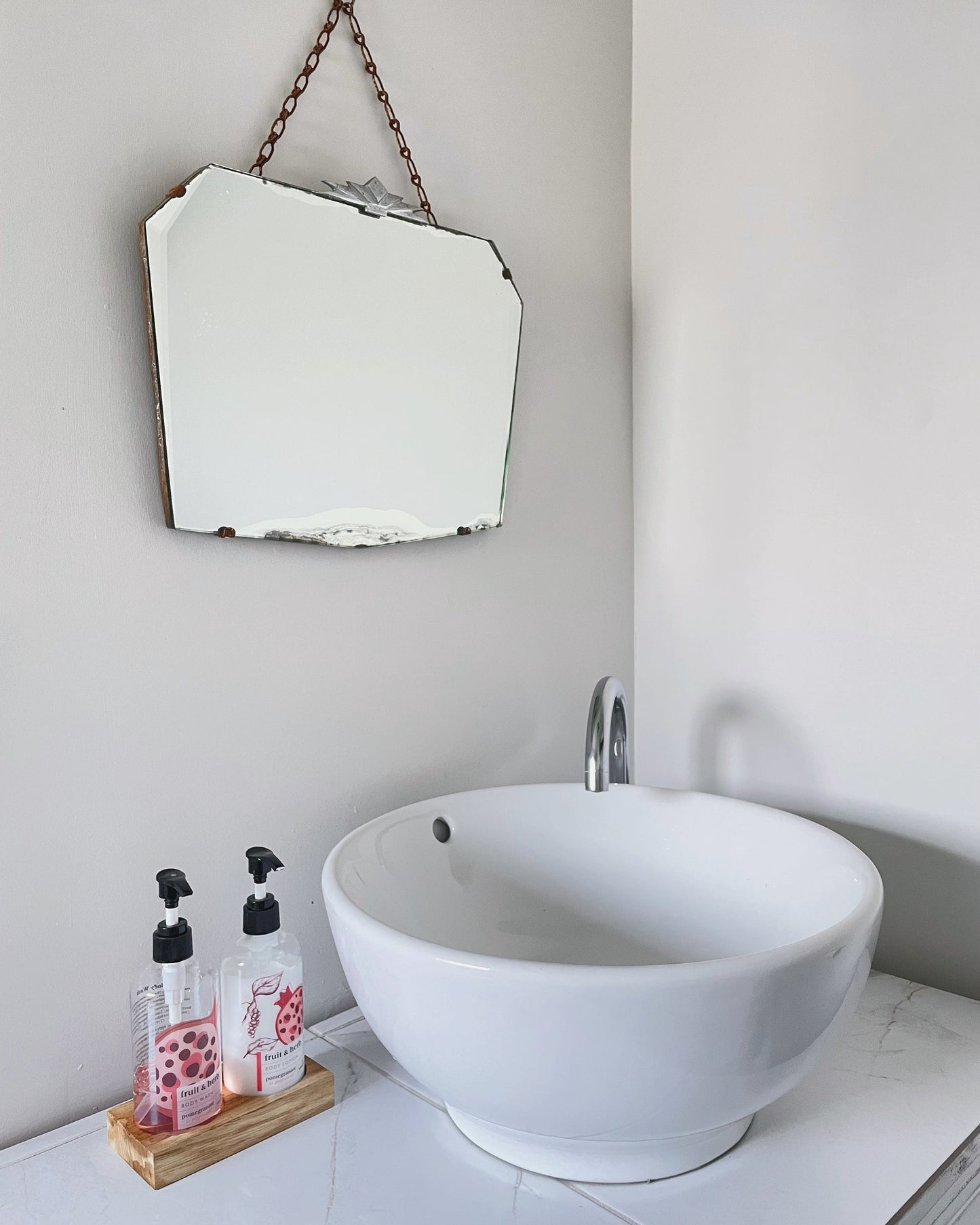 Frameless beveled mirror with Art Deco starburst metal topper